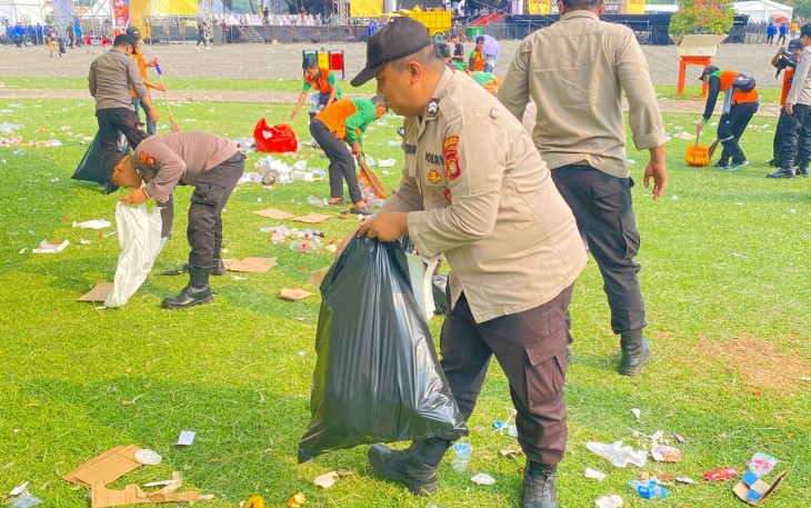 Polres Metro Jakarta Pusat Turun Tangan Bersihkan Sampah Usai May Day di Monas