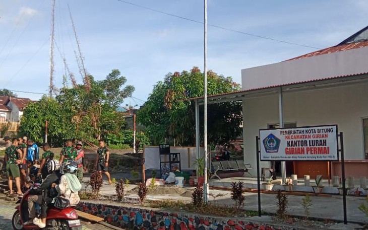 Personel Satgas TMMD Ke-123 Kodim 1310/Bitung saat melakukan pengecoran jalan masuk kantor lurah Girian Permai