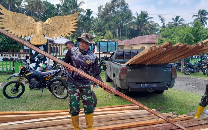 Satgas Pra TMMD ke-124 saat Bongkar Kayu Untuk Pembuatan Baliho