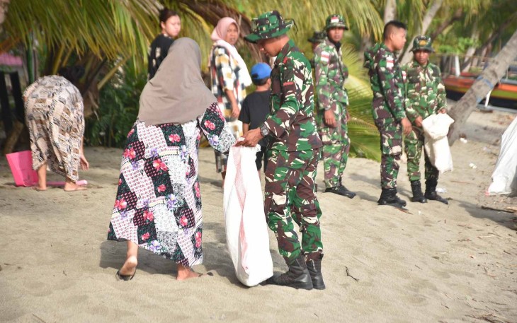 Bersihkan pantai bersama warga