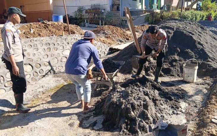 Bripka Andre saat mengaduk adonan pengecoran irigasi