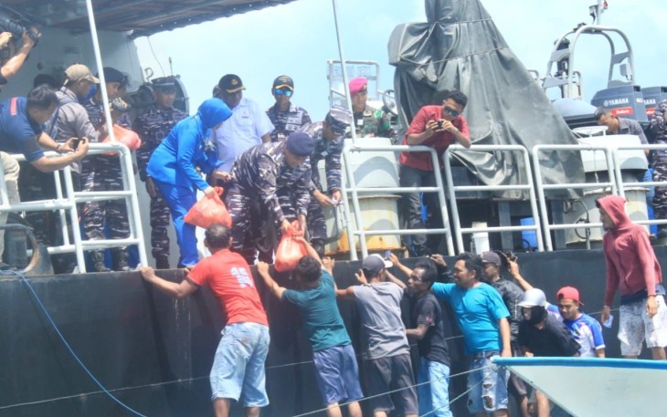 TNI AL mendistribusikan bantuan paket sembako kepada puluhan nelayan yang mendekati KRI Dorang-874 saat melaksanakan lego jangkar di perairan belakang Pulau Wamar, Kepulauan Aru