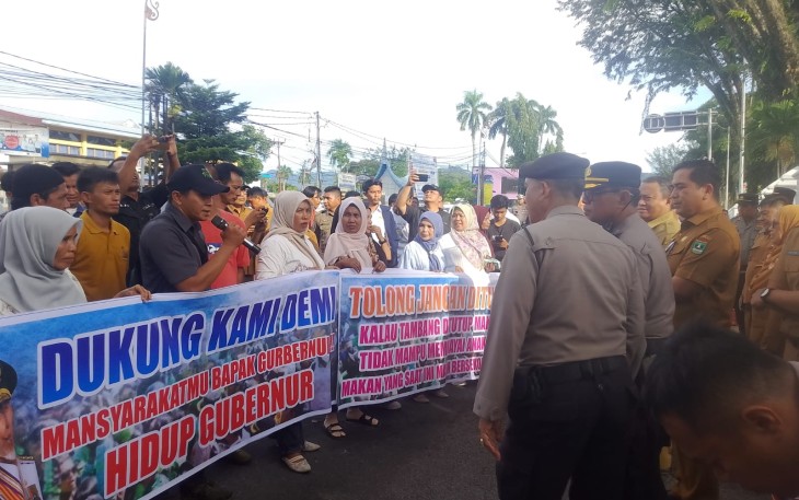 Di bawah terik matahari, puluhan ibu rumah tangga bersama para pekerja tambang membentangkan spanduk berisi harapan dan permohonan kepada pemerintah agar mempertimbangkan nasib ribuan keluarga yang menggantungkan hidup dari aktivitas tambang rakyat