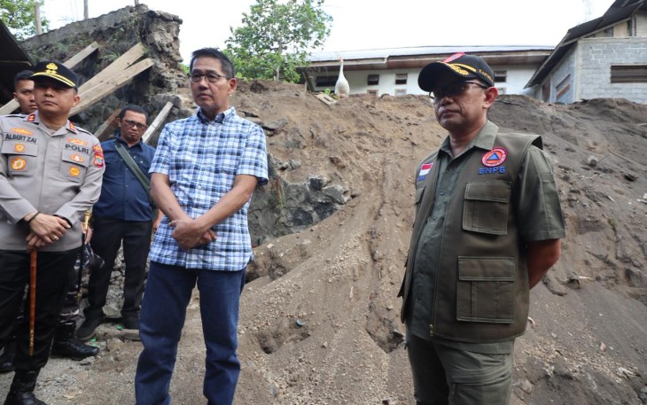 Kepala Pusat Data Informasi dan Komunikasi Kebencanaan (Kapusdatinkom) BNPB, Abdul Muhari (kanan) bersama Wali Kota Bitung, Hengky Honandar (baju kotak-kotak) saat meninjau talud yang rusak mengenai rumah warga setelah diguncang gempabumi M 7,6 di Kelurahan Manembo-Nembo Tengah, Kecamatan Matuari, Kota Bitung, Sulawesi Utara, Jumat (3/4)