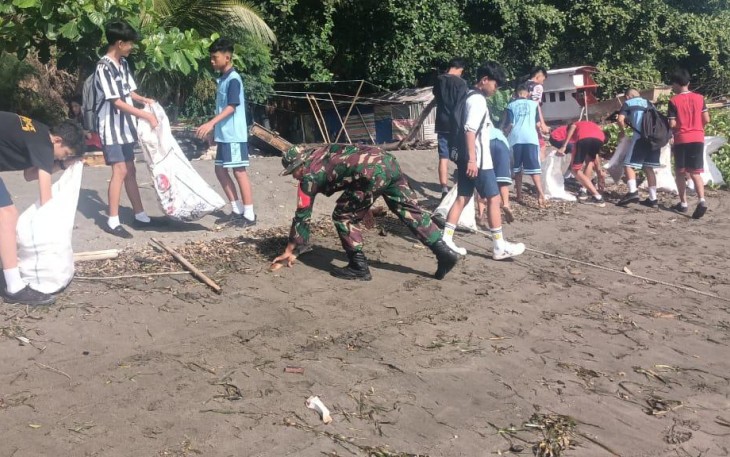 Personil Kodim 1310/Bitung bersama warga dan para siswa saat melaksanakan pembersihan Pantai