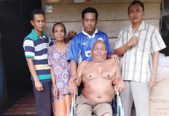 Dukut Sumari S.IP, Kades Melati Harjo didampingi Ketua RT Joko Suprapto dan Tokoh Masyarakat Waluyo, Selasa (11/12/2018) saat menyalurkan bantuan kursi roda di kediaman Pak Men.