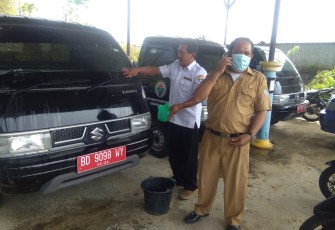 Tampak pegawai Dishub (kiri) saat membersihkan mobil yang belum disalurkan