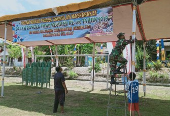Kopda Taufik Bantu Stan Warga Dalam Pasang Banner Pasar Murah Produk Unggulan Masyarakat Desa Cilibang