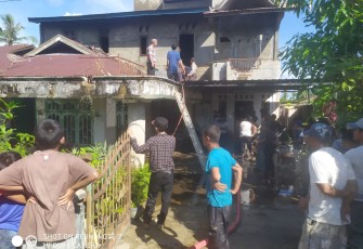 Para petugas bersama warga ketika berupaya memadamkan api yang membakar rumah pensiunan karyawan PLN di Singkil.