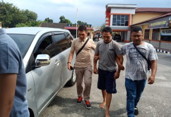 Tersangka (tengah) saat dibawa ke Mapolres Labuhanbatu