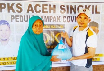 Ketua PKS Aceh Singkil Nasrin S.Pd.I menyerahkan bantuan paket sembako kepada salah seorang penerima.