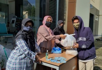 Dr. Eni Zulaiha M.Ag pengurus dosen perempuan peduli Fakultas Ushuluddin (FU) UIN Sunan Gunung Djati (SGD) Bandung tengah membagikan 66 paket sembako kepada para mahasiswa di depan gedung FU
