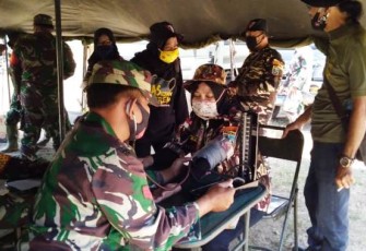 Satgas TMMD memberikan pelayanan kesehatan di posko kesehatan TMMD, Minggu 4/10/2020