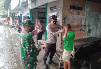 Kapolsek Brangsong AKP Amin Supangat SH MM.,memakaikan masker kepada masyarakat yang tidak taat prokes