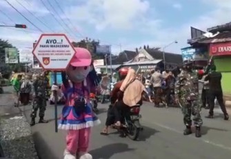 Serda Wawan (Babinsa) memakai Costum Boneka saat lakukan operasi Yustisi