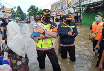 Personel Polri sedang gendong anak kecil dalam rangka evakuasi korban banjir di Jakarta