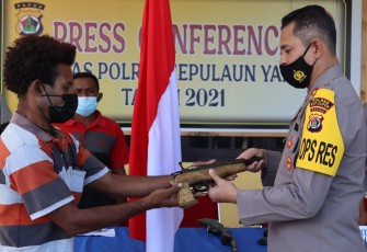Kapolres Kepulauan Yapen, AKBP Ferdyan Indra Fahmi menerima senjata dari Anggota KKB yang menyerahkan diri.