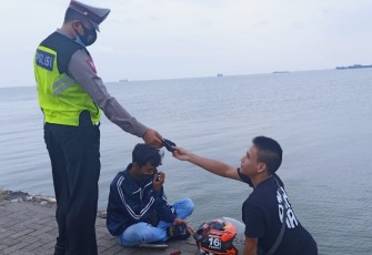 Anggota Satlantas Polres Kendal memberikan masker gratis kepada salah satu pengunjung Pelabuhan Kendal, Jum'at 22/10/2021
