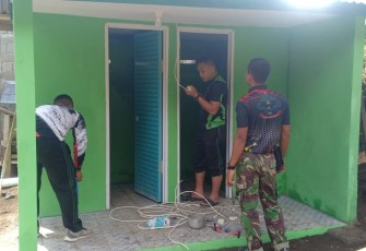 Personil satgas TMMD Ke-111 Kodim 1310/Bitung saat memasang fasilitas tambahan
