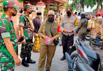 Petugas Patroli Gabungan membagikan masker kepada masyarakat yang berziarah di Jabal Nur Protomulyo. Senin 22/11/2021