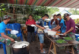 Personil satgas TMMD bersama warga bahu membahu menyiapkan makan siang