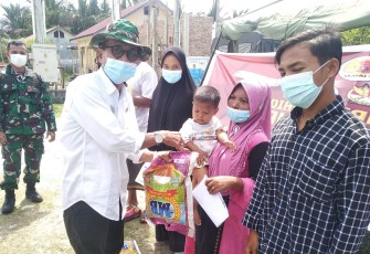 Camat Singkil Sofian, saat menyerahkan beras kepada warga peserta vaksin, dalam kegiatan vaksinasi covid-19 buang dilaksanakan disalah satu desa Kecamatan setempat.
