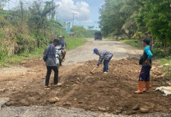 Warga gotong royong timbun jalan berlubang