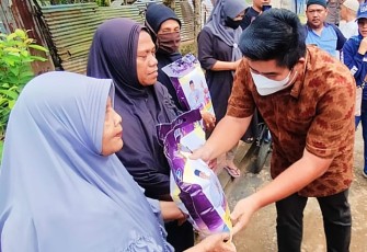 PLT Bupati Bintan Roby Kurniawan SPWK saat membagikan Beras pada warga korban Banjir