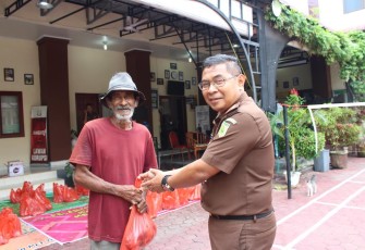 Kajari Aceh Timur Semeru SH, MH saat memberi daging kurban ke salah seorang warga