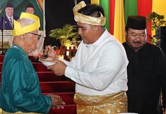 Bupati Bintan Roby Kurniawan SPWK saat memyuapkan nasi tumpeng ke tetua Kabupaten Bintan, Sabtu (03/12/2022).