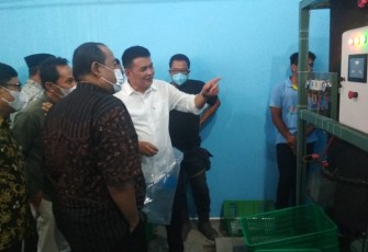 Dirut PUDAM Tirta Lawu, Prihanto (berkemeja putih), saat menerangkan cara kerja mesin produksi es kristal.