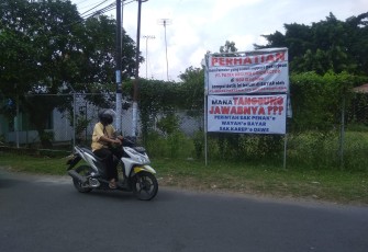 Banner bertuliskan protes kepada PT Minas/Mekar Sampurna yang dipasang vendor lokal di sekitar lokasi lapangan atletik Cepu