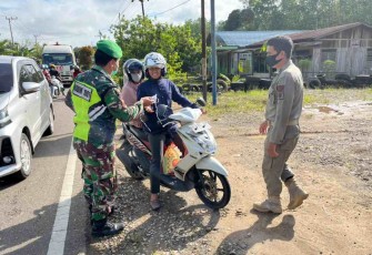 Sertu Kardianto bagikan masker ke pengendara jalan. Senin (09/05/2022)