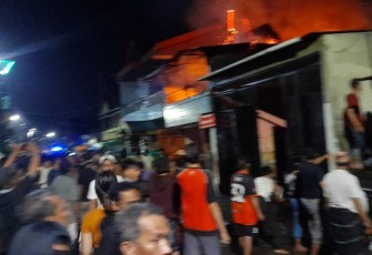 Warga bergotong royong berusaha memadamkan api rumah yang terbakar. Kamis (12/05/2022)