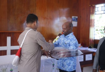 Pendeta Gundius Wandikmo menerima alat musik gitar dari IPDA Murtono SH. Minggu (15/05/2022) 