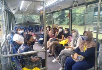 Bus kuning saat melayani penumpang di kawasan universitas Indonesia Depok