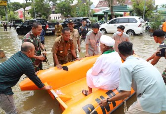 Dandim 1001/HSU-BLG Letkol Inf Dhuwi Hendradjaja saat membantu evakuasi warga terdampak banjir