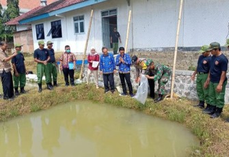 Sertu Sunaryo  saat tebar benih ikan di wilayah desa binaan