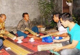 Memainkan alat musik Batak, Menggong. (Foto: Marcel)