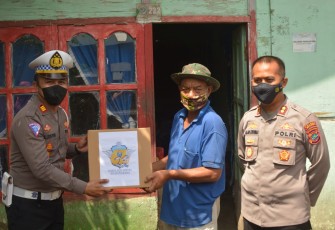 Kapolres Bitung bersama Kasat Lantas saat memberikan bantuan sembako kepada masyarakat kurang mampu