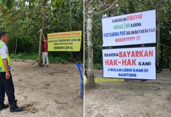 Banner berisi tuntutan protes pembayaran terpasang di area NGU 1X PEPC ADK di desa Nglobo Kecamatan Jiken, Kabupaten Blora, Jawa Tengah.