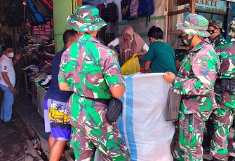 Prajurit Yonmarhanlan VIII Bitung saat membantu para pedagang pasar pindahkan barang dagangannya.
