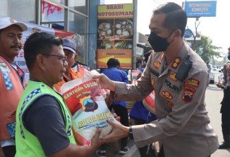 Kapolres Karanganyar AKBP Danang Kuswoyo sedang menyerahkan bantuan beras kepada sejumlah warga yang berada di sekitar lingkungan Mapolres Karanganyar, Jumat (30/9/2022).