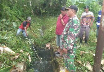 Babinsa Dondang saat Lakukan Komsos saat Gotong Royong bersama Warga