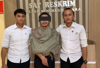 Tersangka (tengah) saat diamankan polisi