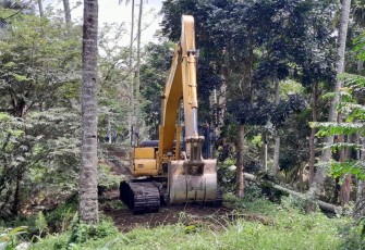 Menggunakan alat eksavator satgas TMMD Kodim 1310/Bitung buka lahan utk pembuatan jalan pertanian