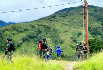 Satgas Yonif Raider 142/KJ dan beberapa orang warga saat bantu memperbaiki instalasi Listrik Solarsel yang diperkirakan mengalami konsleting.