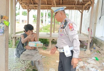 Kasat Lantas Iptu Eko Suhendro, S.H. membawa nasi kotak untuk dibagikan kepada masyarakat pengguna jalan yang melintas di depan Kantor Satlantas Polres Aceh Timur