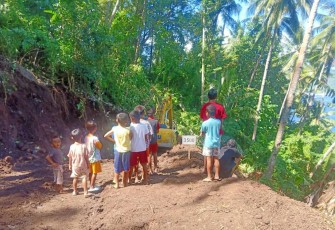Foto anak-anak sekitar lokasi TMMD saat melihat alat berat Eksavator membuka jalan pertanian