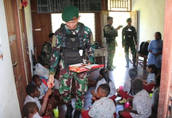 Satgas Mobile Yonif 411/Pandawa Kostrad saat membagikan Nutrisi Tambahan Untuk Anak-anak Sekolah Rimba Batas Batu